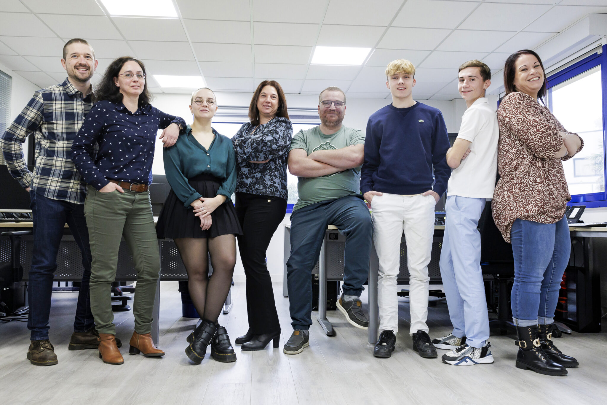 Équipe diverse posant dans un bureau moderne.