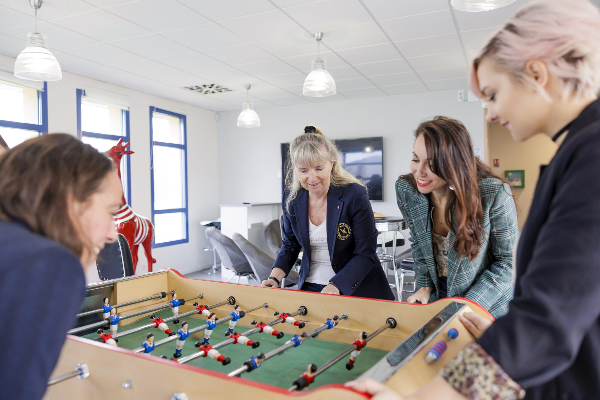Personnes jouant au baby-foot dans un bureau moderne.