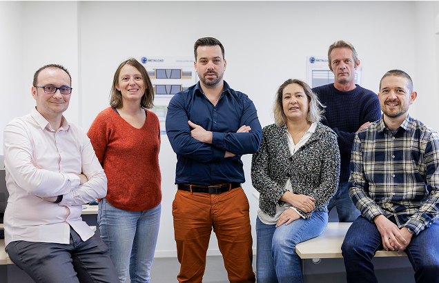 Équipe professionnelle posant dans un bureau lumineux.