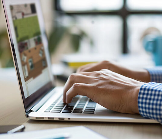 Personne tapant sur un ordinateur portable.